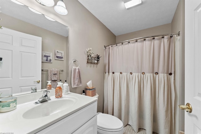 bathroom with a shower with shower curtain, vanity, toilet, and a textured ceiling