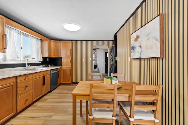 kitchen with dishwasher, light hardwood / wood-style floors, light stone countertops, and sink