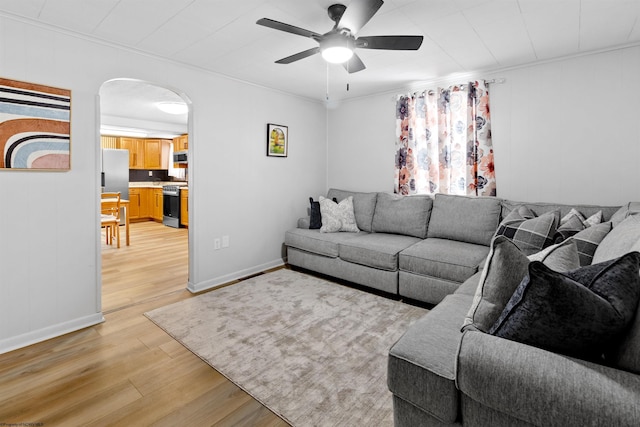 living room with ceiling fan, light hardwood / wood-style flooring, and ornamental molding