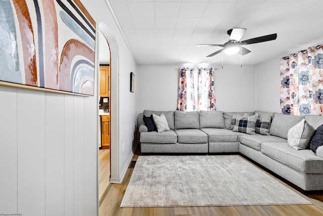 living room featuring ceiling fan, light hardwood / wood-style floors, and ornamental molding