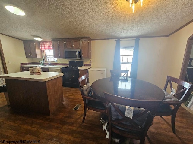 dining area featuring a textured ceiling, dark hardwood / wood-style flooring, and sink