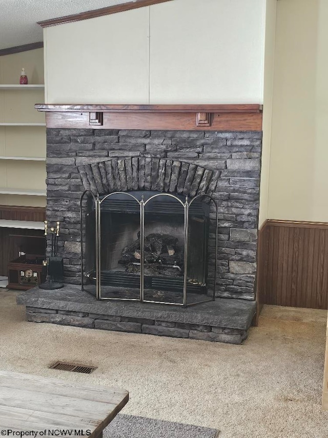 details with built in shelves, wooden walls, a fireplace, and carpet