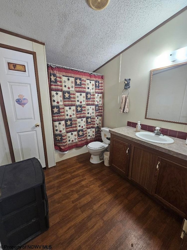 bathroom featuring vanity, a textured ceiling, hardwood / wood-style flooring, and toilet