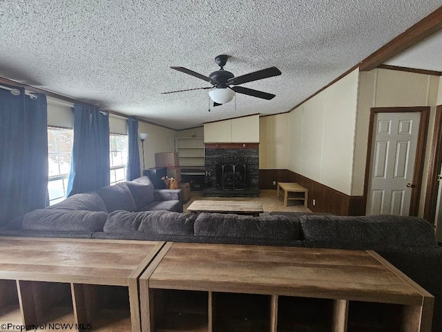 living room featuring a textured ceiling, wood walls, ceiling fan, and lofted ceiling