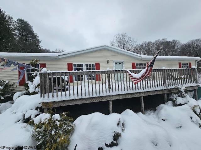 snow covered house featuring a deck