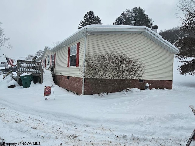 view of snowy exterior with a deck