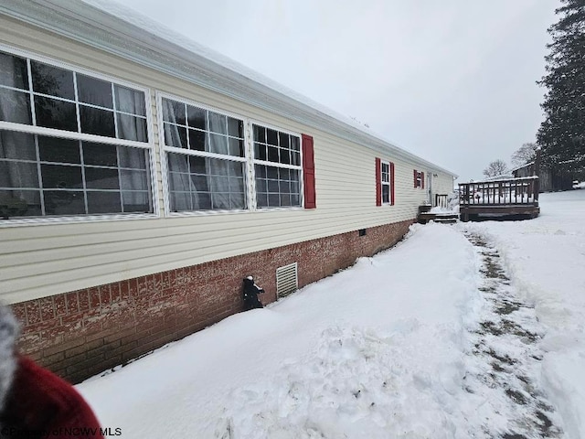 snow covered property featuring a wooden deck