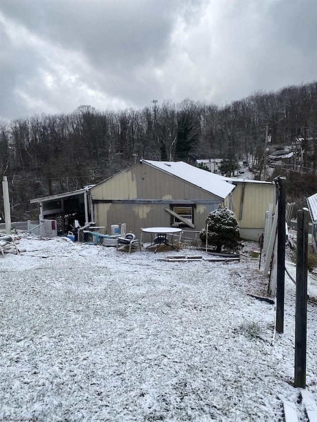 snow covered property with an outbuilding