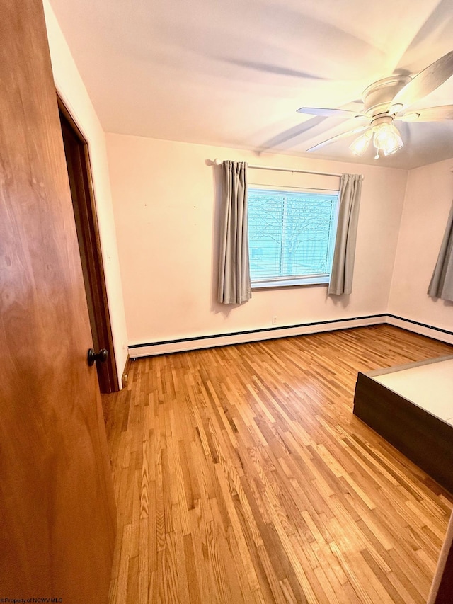 spare room with ceiling fan, light hardwood / wood-style flooring, and a baseboard radiator