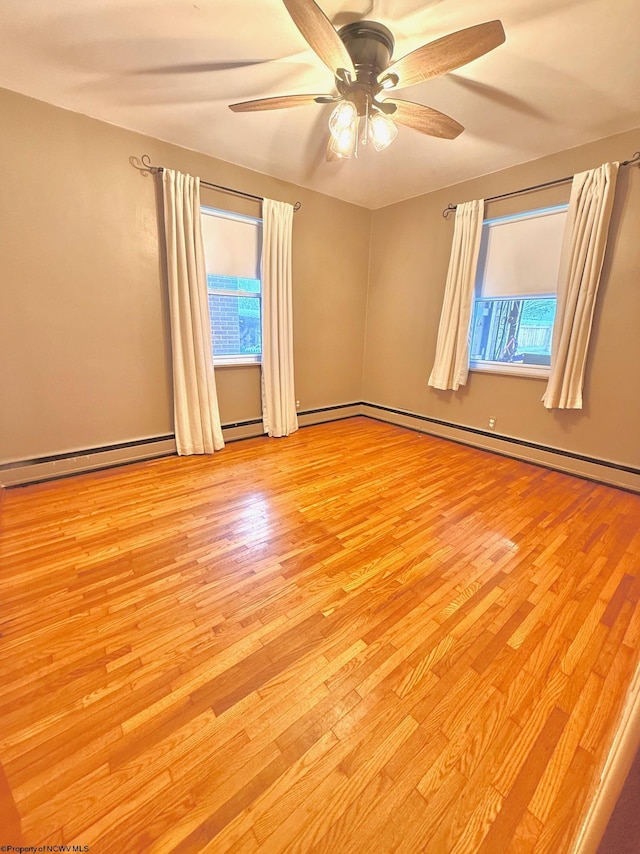 spare room with ceiling fan, light hardwood / wood-style flooring, plenty of natural light, and a baseboard heating unit