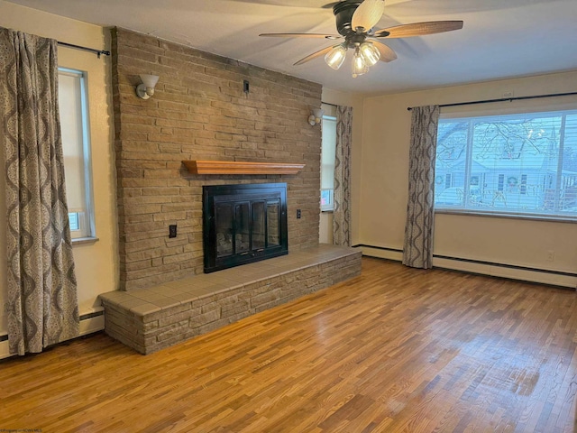 unfurnished living room featuring hardwood / wood-style floors, baseboard heating, a brick fireplace, and ceiling fan