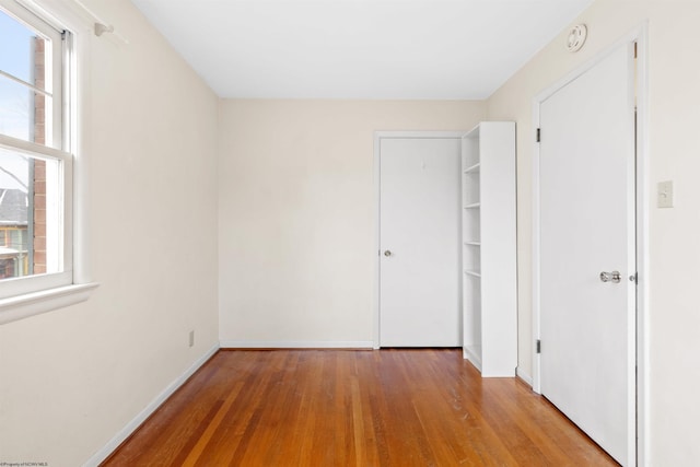 unfurnished bedroom with light wood-type flooring and multiple windows