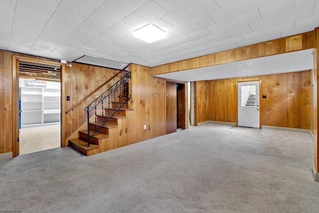 basement with carpet floors and wooden walls