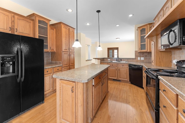 kitchen with black appliances, sink, tasteful backsplash, decorative light fixtures, and a kitchen island