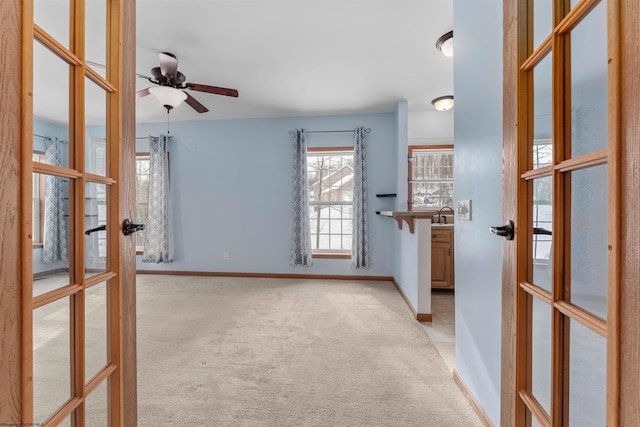 interior space featuring french doors, ceiling fan, and sink