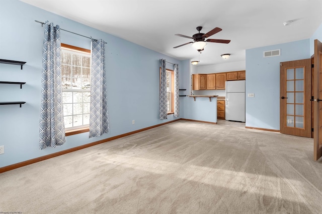 unfurnished living room with ceiling fan and light colored carpet