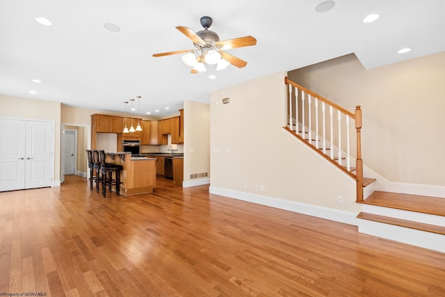 unfurnished living room with light hardwood / wood-style floors and ceiling fan