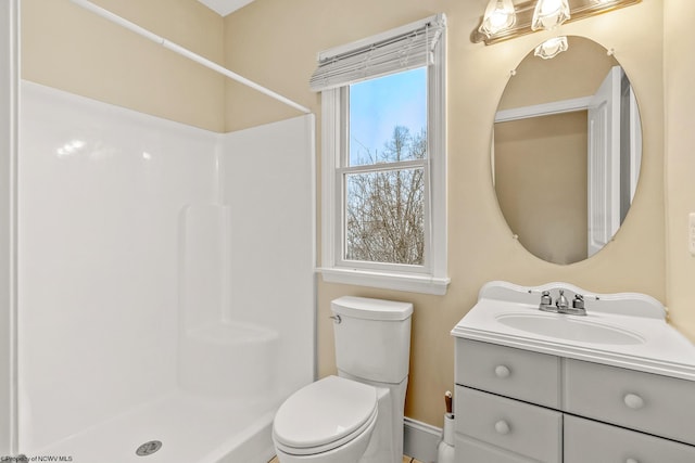 bathroom with walk in shower, vanity, and toilet