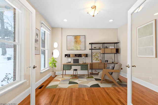 sitting room with french doors, hardwood / wood-style flooring, and a wealth of natural light