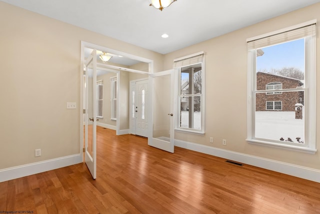 spare room with hardwood / wood-style flooring and french doors