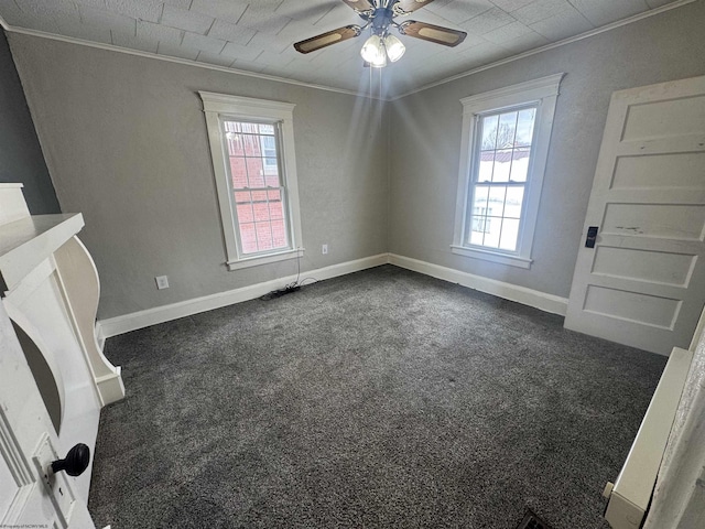 carpeted spare room with ornamental molding, ceiling fan, and a healthy amount of sunlight