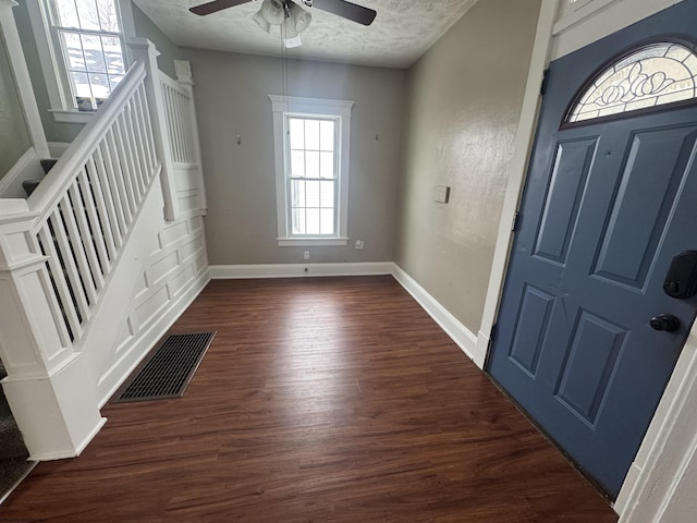 entryway featuring a textured ceiling, ceiling fan, and dark wood-type flooring