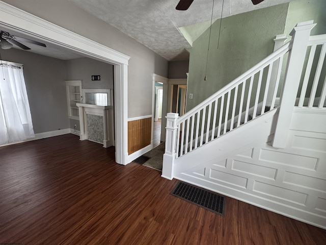 staircase with hardwood / wood-style floors and a textured ceiling