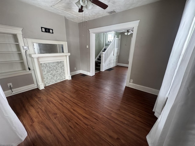 unfurnished living room with dark hardwood / wood-style flooring and a textured ceiling