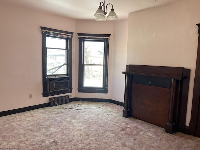 unfurnished living room with light carpet, cooling unit, and a notable chandelier