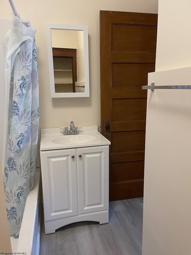 bathroom with vanity, shower / tub combo, and hardwood / wood-style flooring