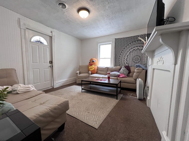 carpeted living room featuring a textured ceiling