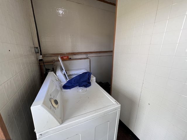 washroom with washer / dryer and tile walls