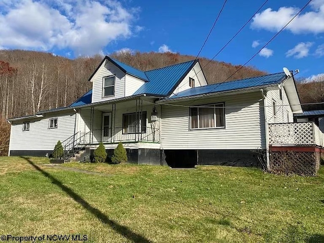 rear view of property featuring a porch and a yard