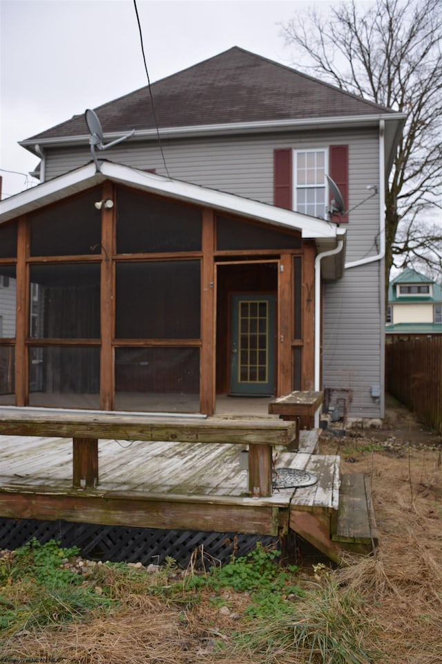 rear view of property with a wooden deck and a sunroom