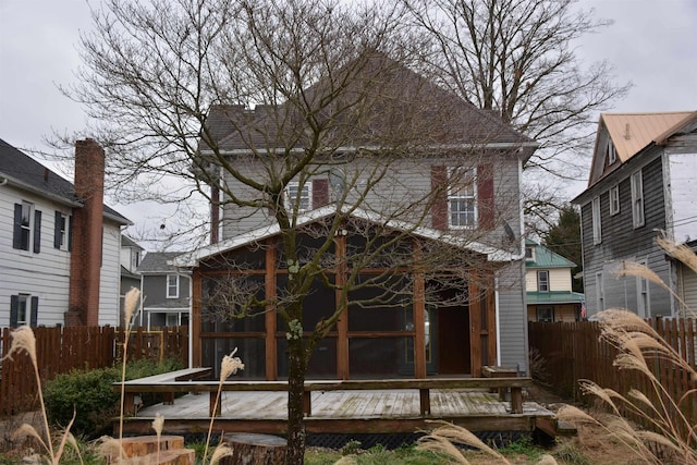 rear view of property with a sunroom and a deck