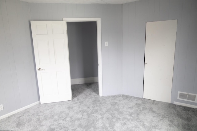 unfurnished bedroom featuring a closet and light colored carpet