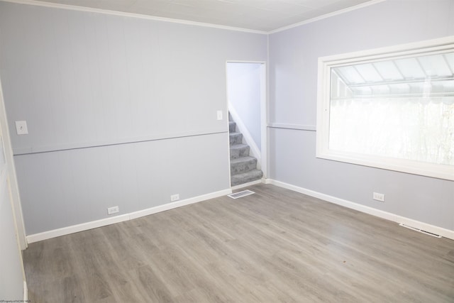 empty room featuring hardwood / wood-style floors and ornamental molding