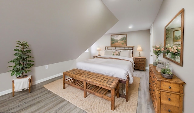 bedroom featuring light wood-type flooring and vaulted ceiling