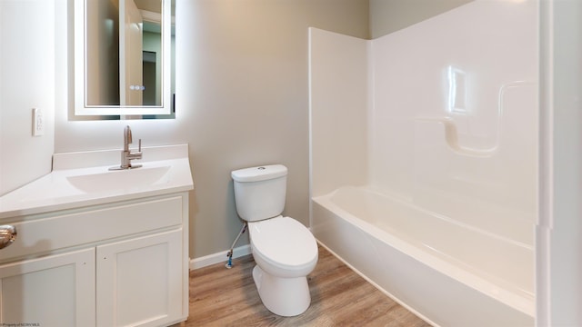 full bathroom with hardwood / wood-style flooring, vanity, bathtub / shower combination, and toilet