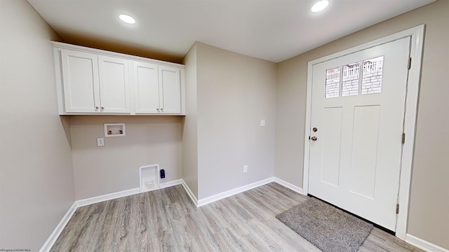 laundry area with electric dryer hookup, cabinets, washer hookup, and light hardwood / wood-style floors