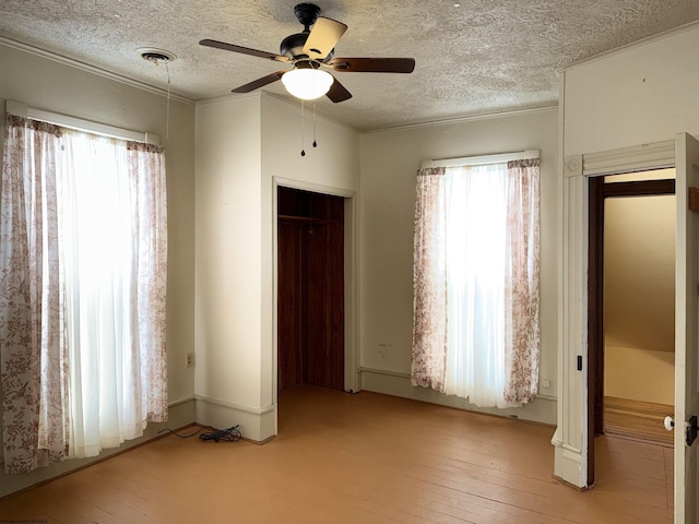 unfurnished bedroom featuring ceiling fan, light hardwood / wood-style floors, a textured ceiling, and a closet