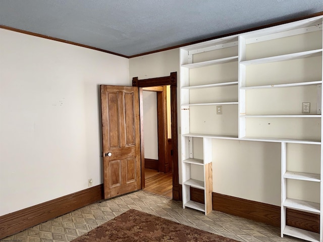 unfurnished bedroom with a textured ceiling and ornamental molding