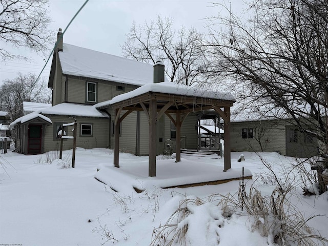 view of snow covered back of property