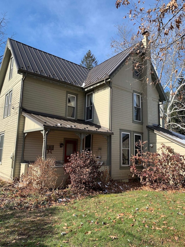 rear view of house featuring a yard