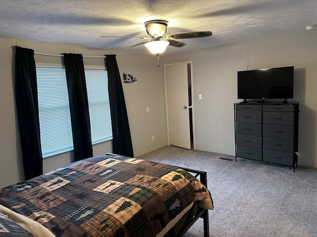 carpeted bedroom with ceiling fan and a textured ceiling