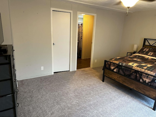 carpeted bedroom featuring ceiling fan and a closet