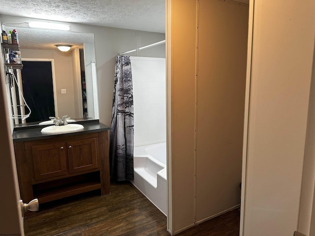 bathroom featuring shower / bath combo with shower curtain, wood-type flooring, a textured ceiling, and vanity