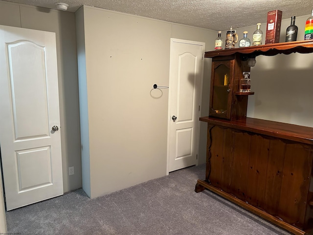 interior space with dark colored carpet and a textured ceiling