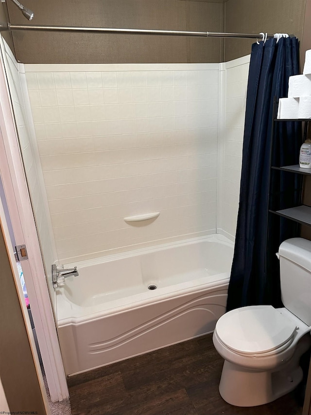 bathroom with hardwood / wood-style floors, toilet, and shower / bath combo with shower curtain