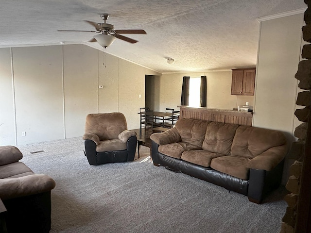 carpeted living room with ceiling fan, lofted ceiling, a textured ceiling, and ornamental molding